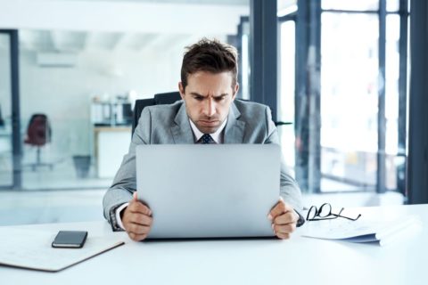business man getting frustrated by his computer